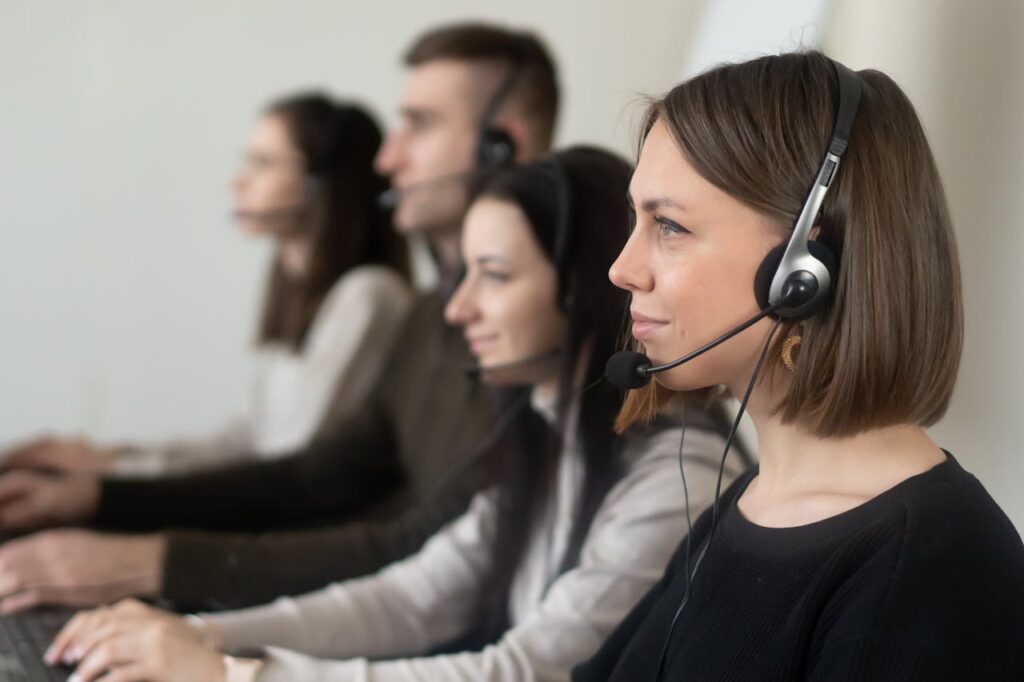 Operators with headphones with microphone working on netbook in room